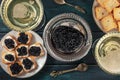 Black caviar with champagne in vintage coupe glasses, with toasts, a flat lay, top shot