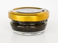 Black caviar in a glass jar with a golden lid on a white background. Sturgeon caviar, fish delicacy Royalty Free Stock Photo