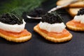 Black caviar served on crackers with salmon and cream cheese Royalty Free Stock Photo