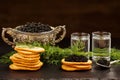 Black caviar served on crackers with vodka and additives