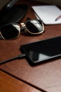 Black cellphone charging on a desk