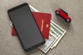 Black cellphone, money American dollars banknotes bills, passport and toy car on copy space background, top view. Travel light, Royalty Free Stock Photo