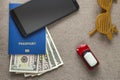 Black cellphone, money American dollars banknotes bills, passport, toy car and funny sunglasses on copy space background, top view Royalty Free Stock Photo