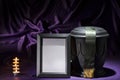 Black cemetery urn with black blank mourning framewith green ribbon on deep purple background