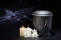 Black cemetery urn with burning candle white chrysanthemum on deep blue background Royalty Free Stock Photo