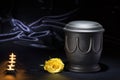 Black cemetery urn with candles yellow rose on deep blue background Royalty Free Stock Photo