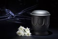 Black cemetery urn with white chrysanthemum, on deep blue background Royalty Free Stock Photo