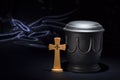 Black cemetery urnk with wooden cross on deep blue background Royalty Free Stock Photo