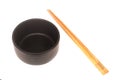 Black ceramic bowl with wooden shopsticks isolated