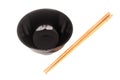 Black ceramic bowl with wooden shopsticks isolated