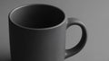Black ceramic mug with matte surface and rounded handle on neutral gray background Royalty Free Stock Photo