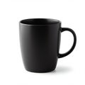 A black ceramic mug with a smooth surface and a sturdy handle. It has a matte finish Royalty Free Stock Photo