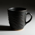 A black ceramic mug with a textured surface, featuring subtle horizontal grooves. The Royalty Free Stock Photo