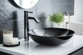 Black ceramic round sink and chrome faucets in the bathroom. Minimalist modern bathroom interior design