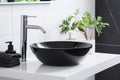 Black ceramic round sink and chrome faucets in the bathroom. Minimalist modern bathroom interior design