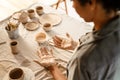 Black ceramist woman looking at her hands while working at her workshop