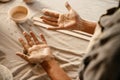 Black ceramist woman looking at her hands while working at her workshop