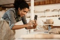 Black ceramist woman taking photo while working at her studio