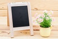 Black chalkboard lying with flowers.