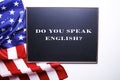 Black chalkboard with the question do you speak English? written in it and the flag of the United States of America. Royalty Free Stock Photo