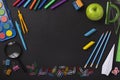 Black chalkboard school background with school supplies and stationery items, empty copy space for text Royalty Free Stock Photo