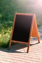 A black chalkboard stand on wood for a restaurant menu in the street. Empty menu board on street. Empty menu board on street on Royalty Free Stock Photo