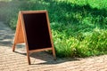 A black chalkboard stand on wood for a restaurant menu in the street. Empty menu board on street. Empty menu board on street on Royalty Free Stock Photo