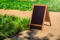 A black chalkboard stand on wood for a restaurant menu in the street. Empty menu board on street. Empty menu board on street on Royalty Free Stock Photo