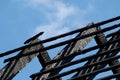 Black charred burnt wooden roof rafters after fire under blue sky Royalty Free Stock Photo