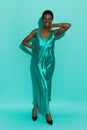 Black cheerful woman in a turquoise satin long dress