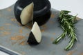 Black cheese with rosemary on chopping board