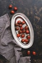 Black cherry tomato in a metal dish on a dark rustic background. Top view, flat lay Royalty Free Stock Photo