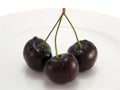 Black cherry on a white plate close-up Royalty Free Stock Photo