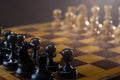 Black chess pieces against white chess pieces on a chessboard Royalty Free Stock Photo