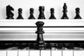 Black chess pieces on white piano Royalty Free Stock Photo