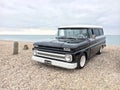 Black 1964 Chevrolet Suburban parked on the beach Royalty Free Stock Photo