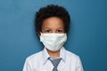 Black child boy student in medical protective face mask on blue background Royalty Free Stock Photo