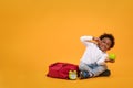 Black child boy 3 years, Student kid holding green apple in his hand and thinking point to head while sitting with school bag and Royalty Free Stock Photo