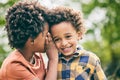 Black children, friends and whisper secret, happy and bonding together outdoor. African kids, smile and gossip in ear Royalty Free Stock Photo