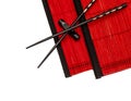 Black chinese chopsticks on red bamboo mat. asian style