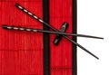 Black chinese chopsticks on red bamboo mat. asian style Royalty Free Stock Photo