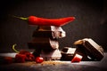 Black chocolate, red pepper spiciness   on a dark background Royalty Free Stock Photo