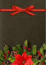 Black Christmas background with fir-tree twigs and red ribbon bo Royalty Free Stock Photo