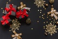 Black Christmas gifts with red bows on a black background with gold snowflakes and decorations. Flat lay, copy space Royalty Free Stock Photo