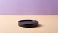 Black circular container on beige surface against purple background Royalty Free Stock Photo