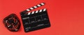 BLACK Clapper board and hacker mask on red background.No people