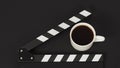 Black clapperboard or movie slate with hot coffee on black background.