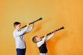 Black clarinet on an orange background in the hands of young performers of the folk mazy. Two brothers with clarinets, performing
