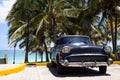 A black classic car parked near the beach