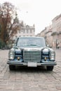 Black classic retro car parked in old European city street. Vintage old black car in front of Lviv city center. Royalty Free Stock Photo